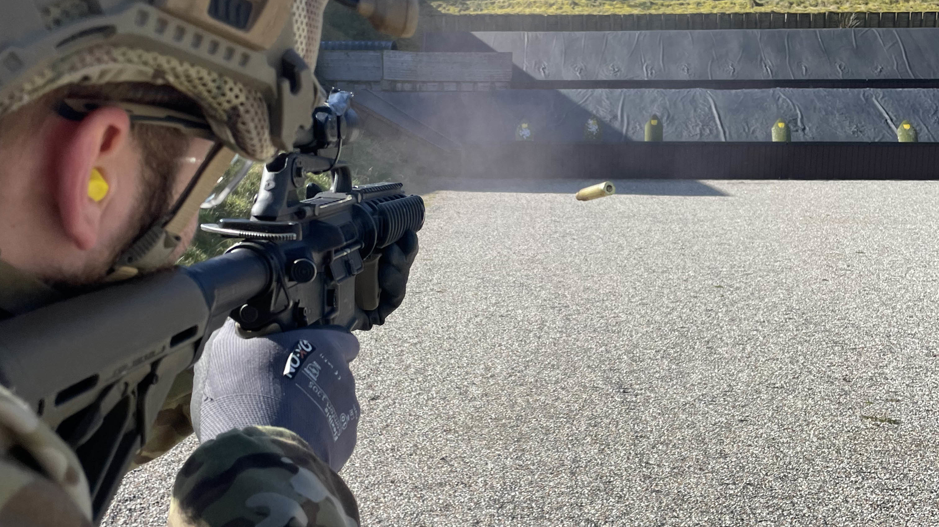 Person skyder med automatgevær på skydebane.