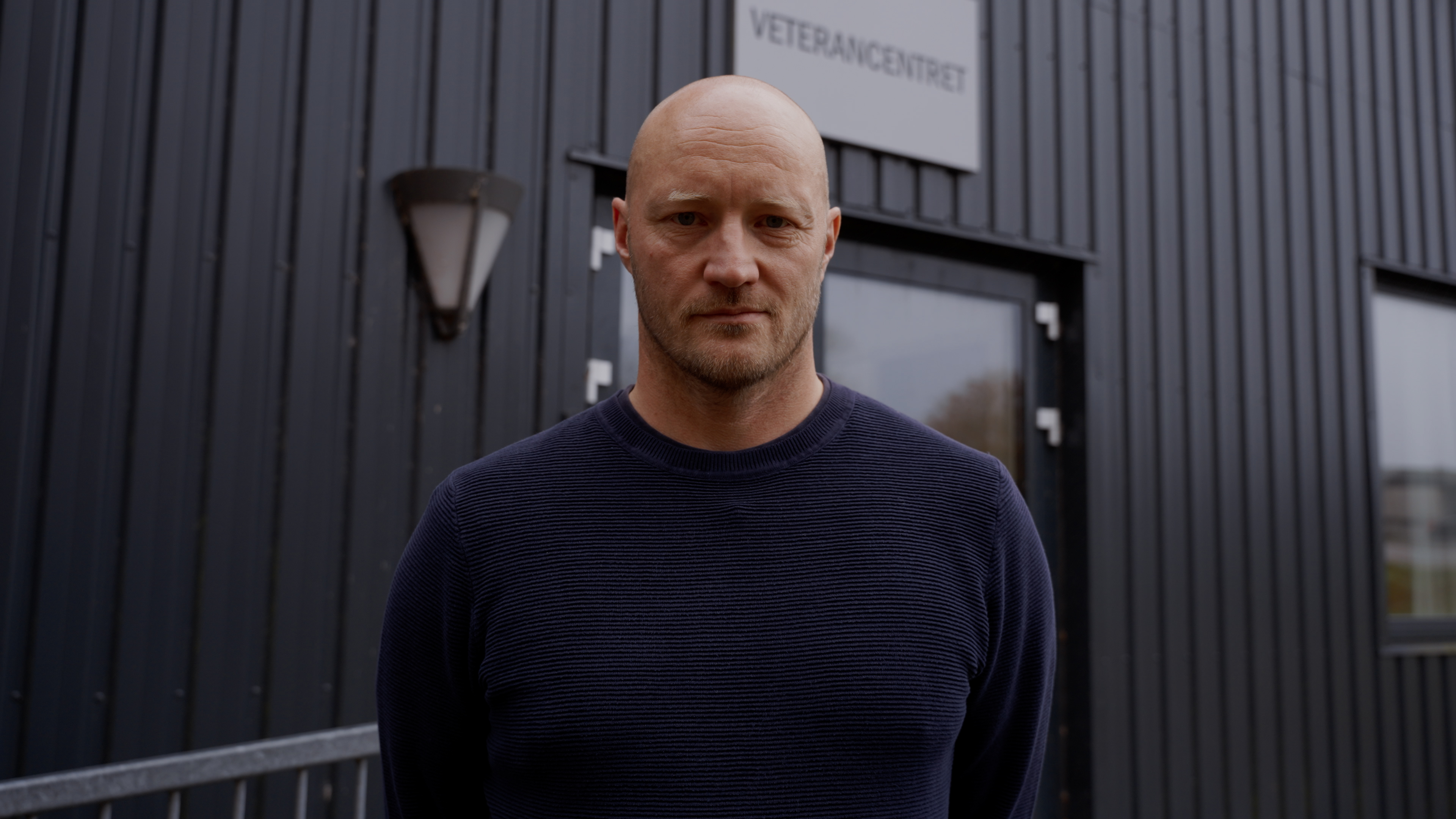 Militær psykolog Anders står foran en bygning og kigger ind i kameraet