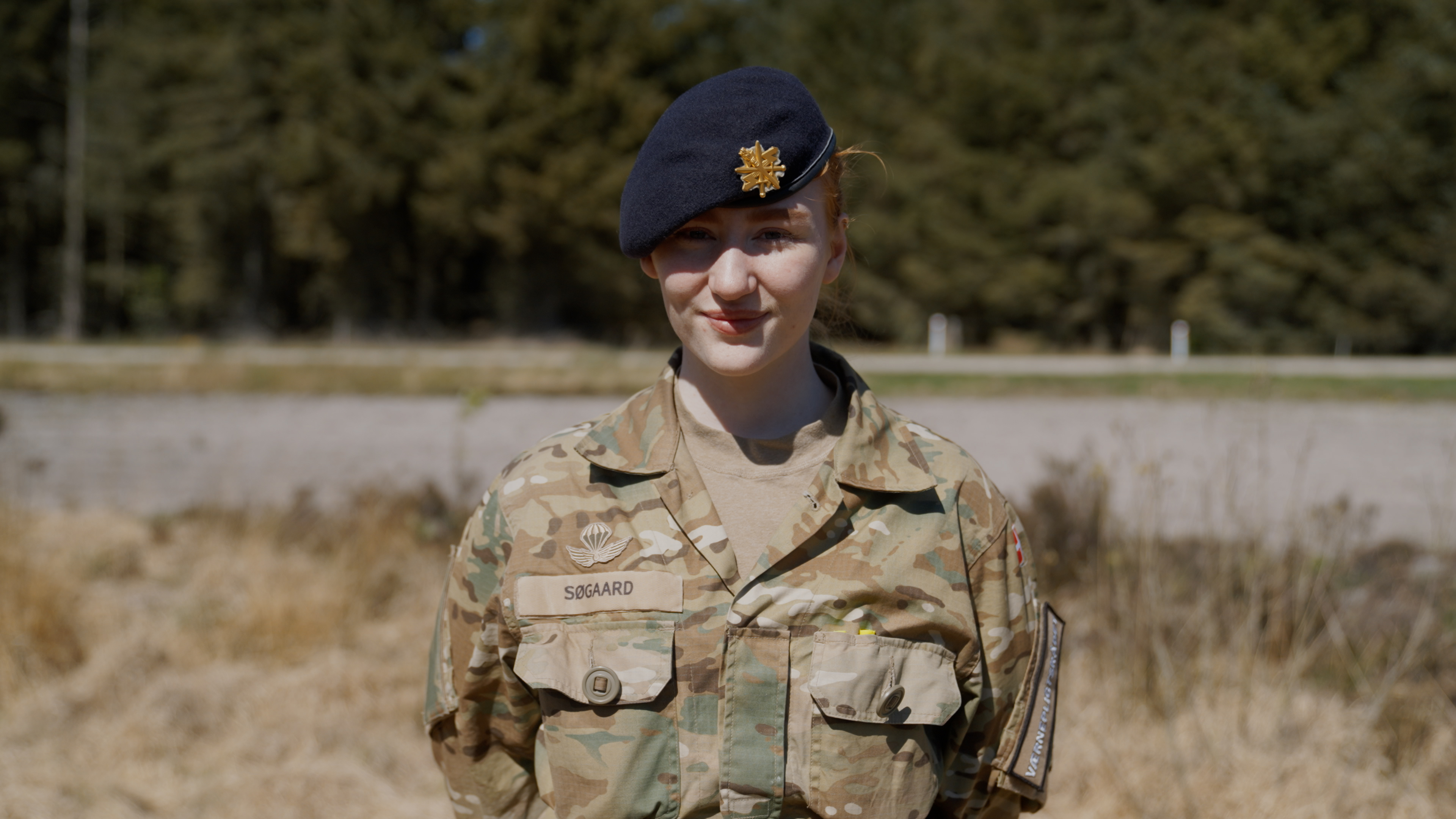 Værnepligtsrepræsentant Emmely står med armene på ryggen og kigger ind i kameraet