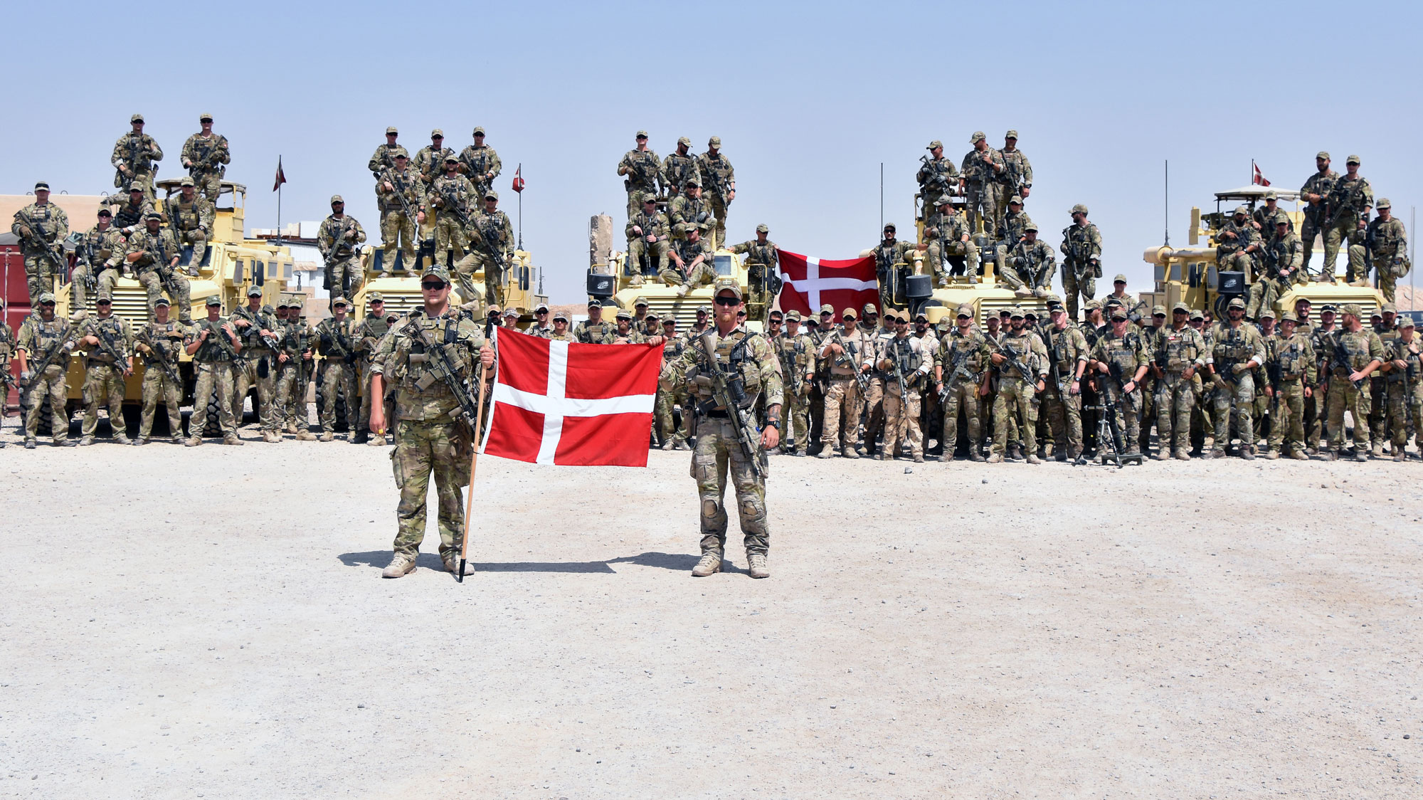 Billede af en masse danske soldater med danske flag.