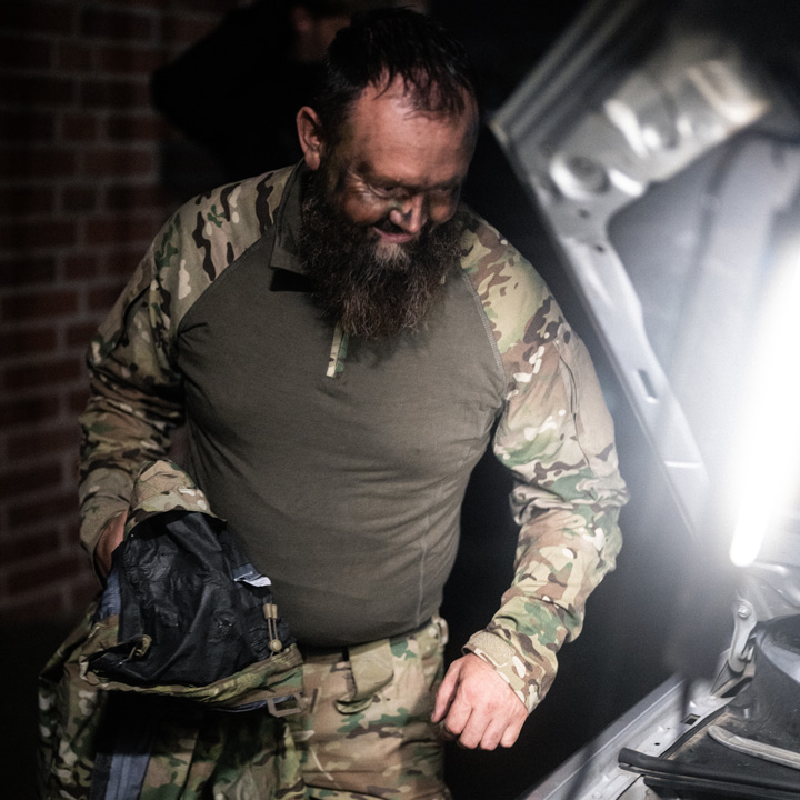 Soldat i uniform står ved siden af åbent motorrum