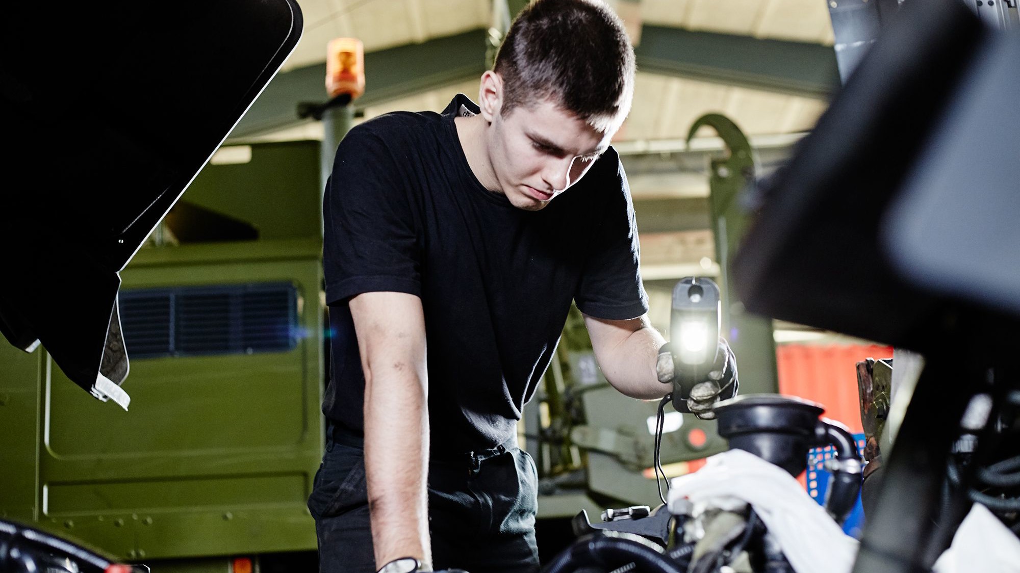 Lastvognsmekaniker bruger lys til at lyse ved noget mekanik