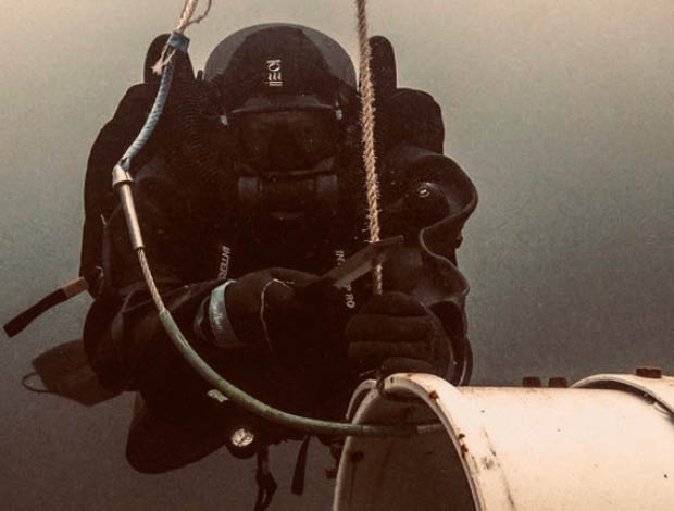 Minedykker fra Forsvaret arbejder under vand med specialudstyr.
