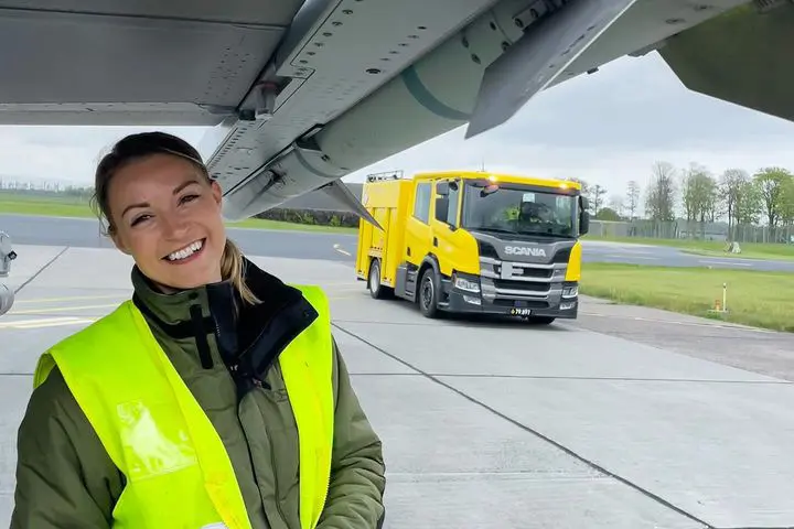 Melinda arbejder med fly og har en gul sikkerhedsvest på