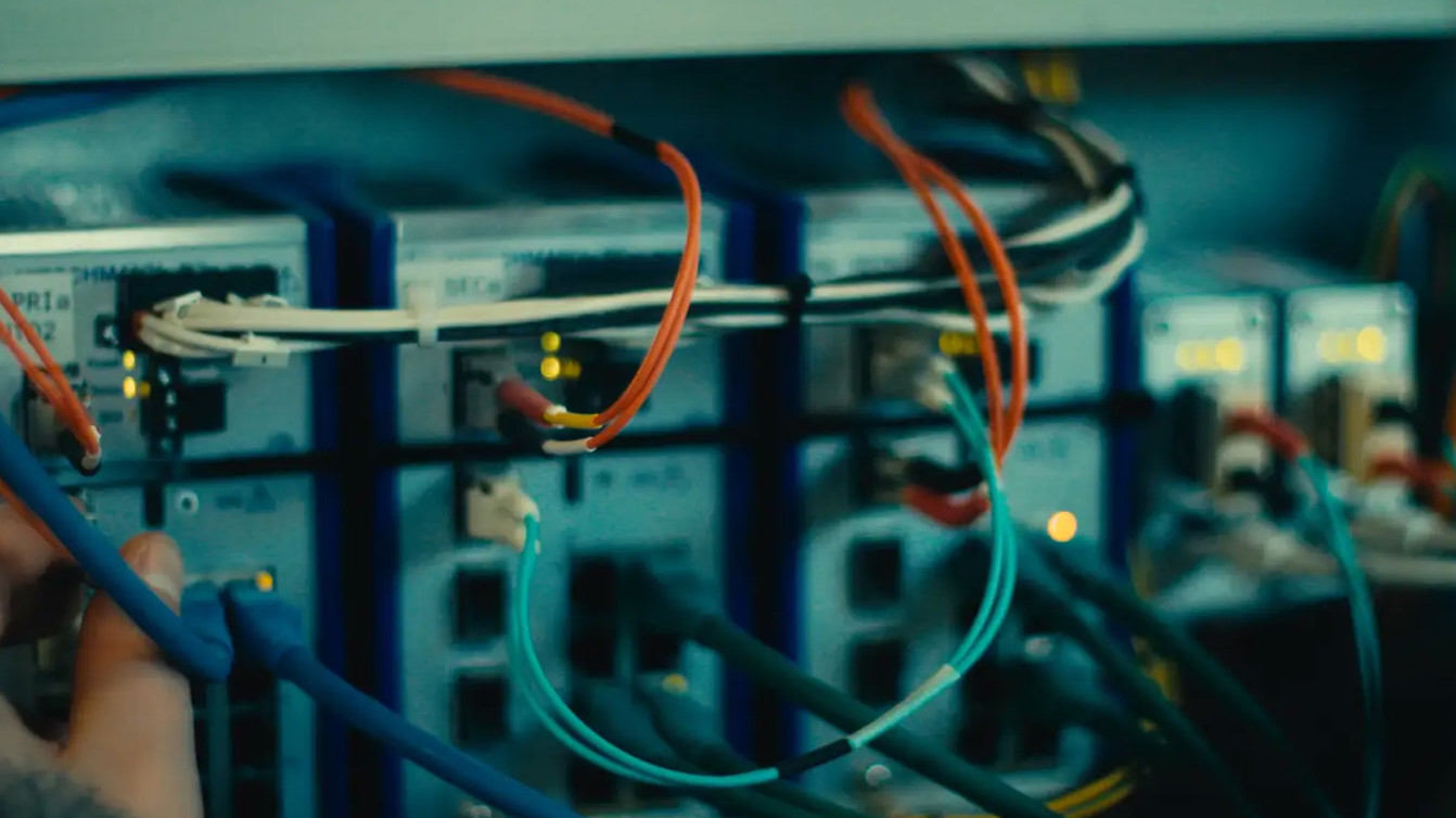 Nærstudie af IT-hardware, servere og netværkskabler, der understøtter Forsvarets Informationsteknologi.