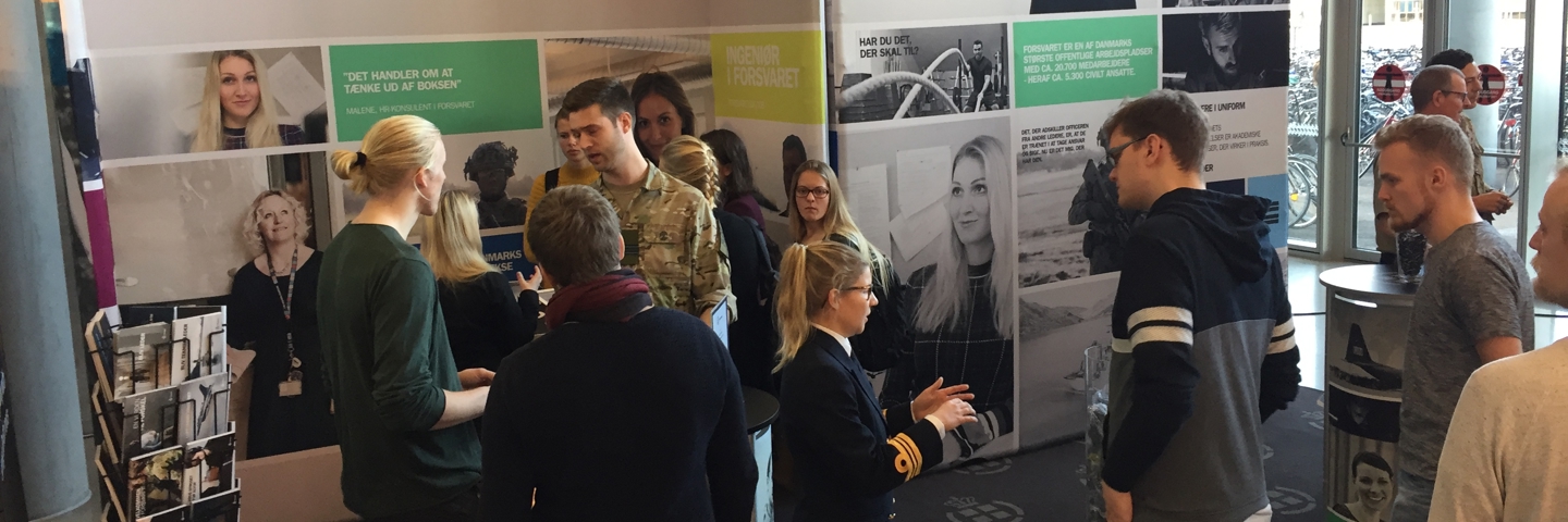 Unge mennesker og soldater på en stand ved en uddannelsesmesse