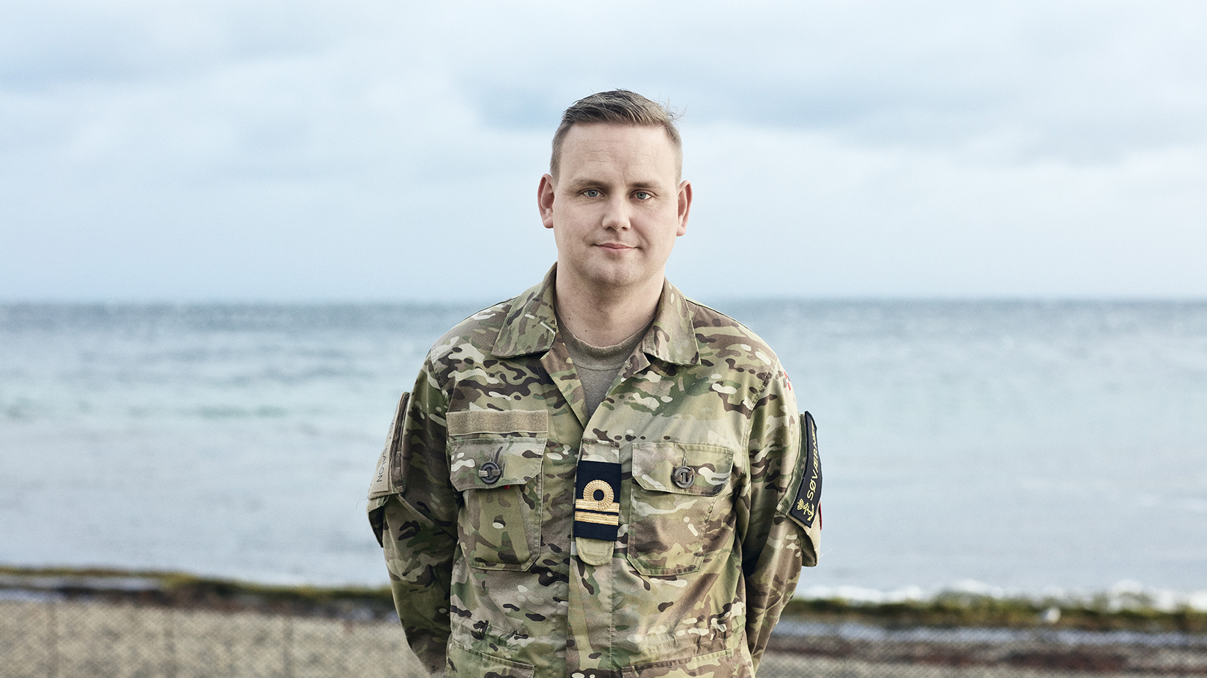 Bjarke kigger ud mod kameraet i sin uniform og smiler