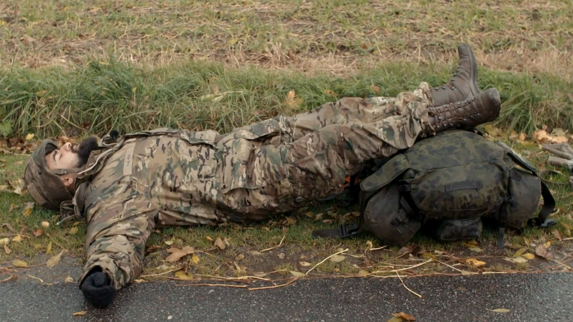 Soldat ligger på jorden med udstrakte arme og lukkede øjne