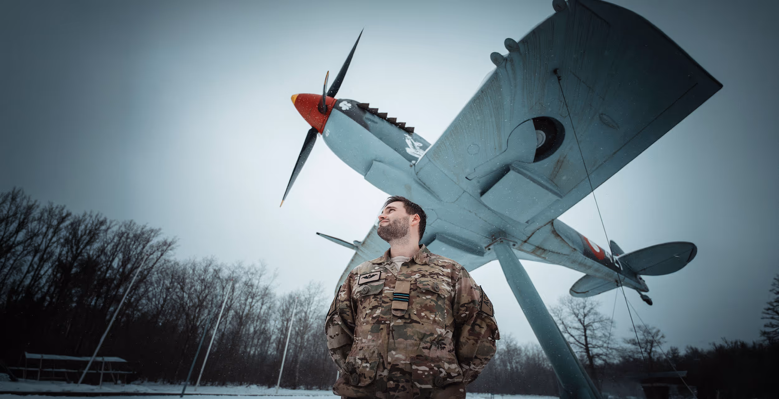 Benjamin står på en flyvestation og kigger op mod luften