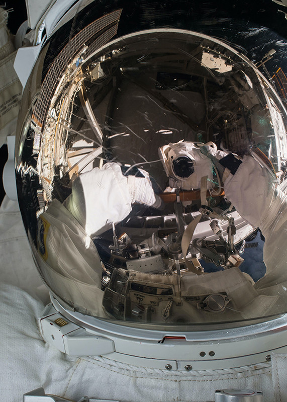 Refleksion af astronaut og udstyr i visiret på en rumdragt