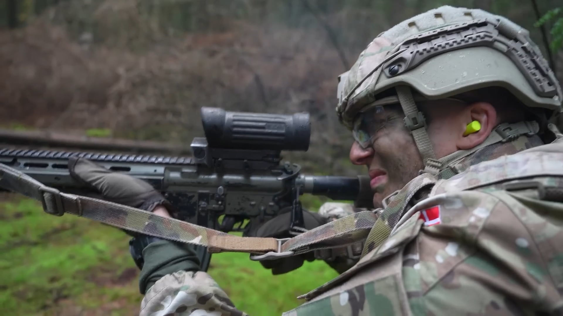 Hav ligger i et skovområde med militær uniform og et gevær